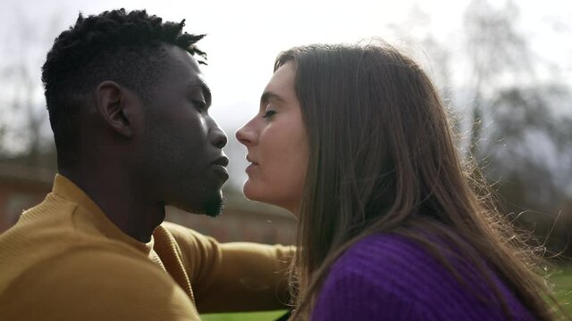 Young interracial couple kiss. Millennial lovers, African and white couple