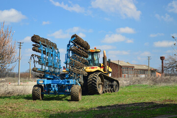 The tractor with modern farm equipment, cultivator or plow
