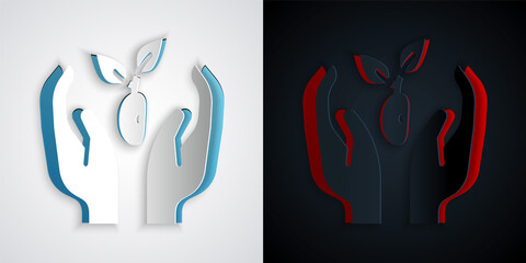 Paper cut Plant in hand of environmental protection icon isolated on grey and black background. Seed and seedling. Planting sapling. Ecology concept. Paper art style. Vector