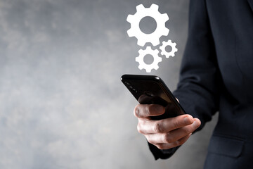 Business man in suit holding metal gears and cogwheels mechanism representing interaction teamwork concept,hand hold group of virtual cog gears wheel