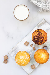 Vanilla muffins and muffins with streusel in paper cups with a glass of milk. Breakfast or snack for children.