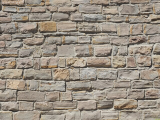 A wall with rough masonry of different sizes illuminated by sunlight. Not seamless texture