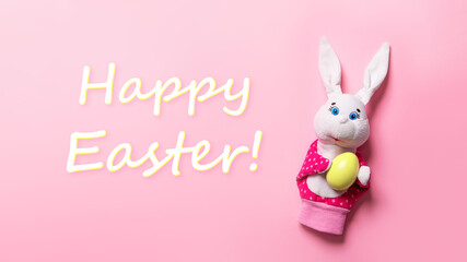 Banner with bunny, word Happy Easter, painted yellow egg on pink background with copy space, text place. Christian holiday card. Springtime. Online course of toy theater. Hand puppet. Childhood play