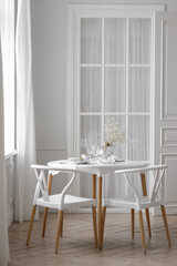 White loft interior in a Scandinavian style with a table. Set wooden table in a bright interior, photo studio.