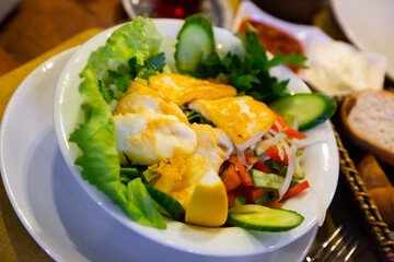 Appetizing Turkish salad with fried halloumi cheese from sheep and goat milk with fresh vegetables, greens and lemon