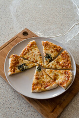 sliced homemade pizza margarita with basil on a plate