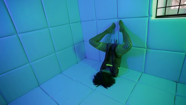 extravagant sexy lady dressed net suit is posing strange in room