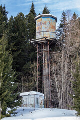 Abandoned waterworks in the forest. A high water tower abandoned in the forest.