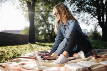 Woman typing on a laptop at park