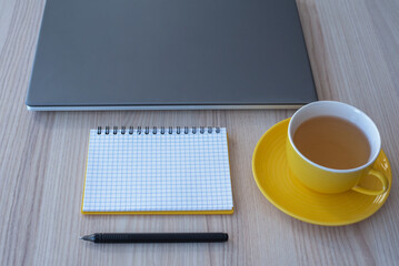 laptop, notebook, cup of tea, pen on the table