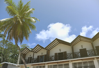 Exterior of building with summer appartments for rent on tropical beach.