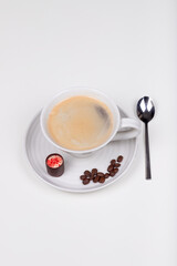 A cap of coffe with sweet and coffee beans