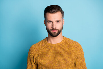 Photo of young handsome attractive serious man look camera wear yellow orange sweater isolated on blue color background