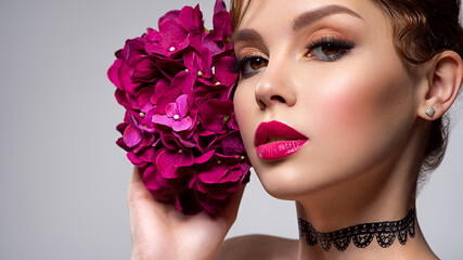 Beautiful white girl with purple flowers. Stunning brunette girl with big violet bouquet flowers....