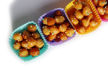 Traditional italian fried Struffoli with honey and sugar sprinkles  isolated on white background