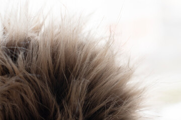 a piece of brown, artificial fur on a light background. The texture of artificial materials. Allergy, an alternative to natural fur. Animal protection