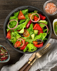 Fresh vegetables salad on wooden background. Healthy eating concept.