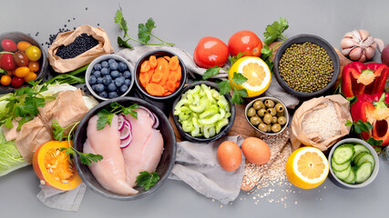 Selection of organic raw healthy products on gray background product.