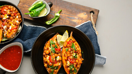 Stuffed sweet potato with spiced chickpea, dressing and herbs.