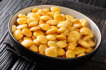 Healthy vegetarian pickled lupine beans close-up in a bowl on the table. horizontal
