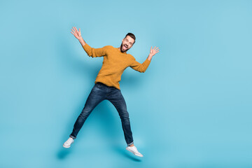 Fototapeta na wymiar Full length body size view of attractive cheerful carefree guy jumping fooling having fun isolated on bright blue color background
