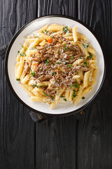 Genovese sauce is a rich, onion based pasta sauce served with pasta close up in the plate on the table. Vertical top view from above