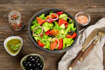 Fresh vegetables salad on wooden background. Healthy eating concept.