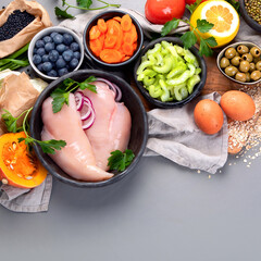 Selection of organic raw healthy products on gray background product.