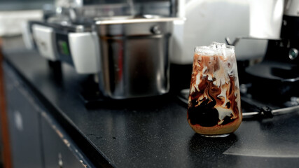 Close-up glass of iced coffee with milk on the table