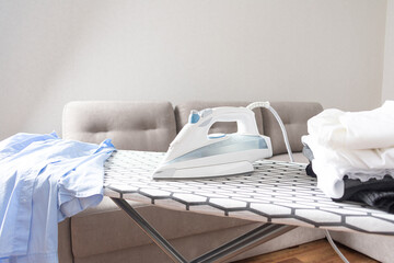 Modern new electric iron on iron board with shirts