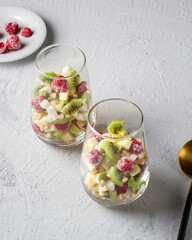 Fruit pieces and raspberries in glass glasses