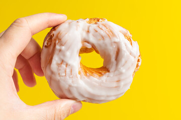 Sweet chocolate donut on yellow background. Dessert food