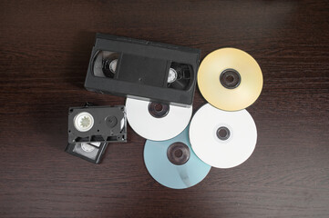 videotape and cd on brown wooden background