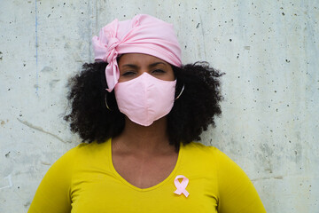 african-american woman with a pink scarf and pink mask sanitary and yellow t-shirt