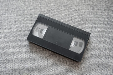 Old tape video cassette on a gray knitted background