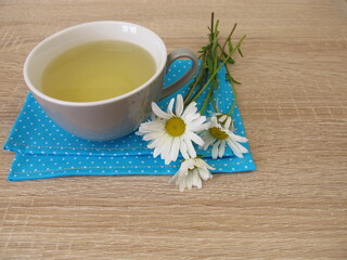 A cup of herbal tea with flowers from the ox-eye daisy