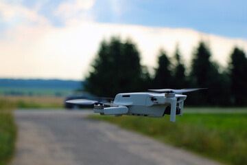 The drone flies over the road on a sunny day.