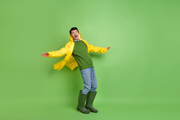 Full body profile side photo of young man surprised catch strong wind wear raincoat sweater...