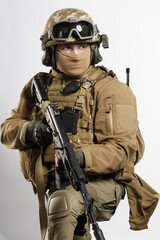 Male soldier in tactical equipment and uniform (coyote brown color) . Shot in studio on a white...