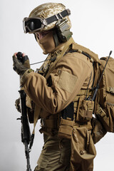 Male soldier in tactical equipment and uniform (coyote brown color) . Shot in studio on a white...
