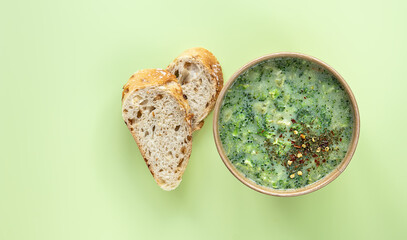 Healthy food delivery concept. Fresh broccoli cream soup served fresh bread and spices in craft...