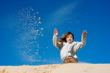 cute little girl having fun with sand dunes