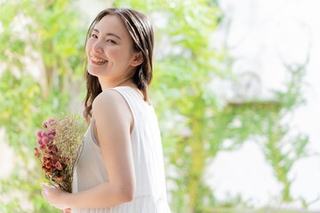 Naklejka premium お花を持った若い日本人女性 ポートレート