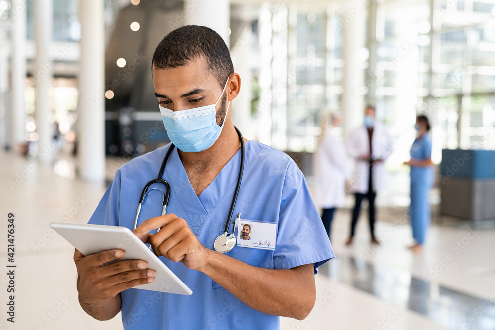 Wall mural Mixed race nurse using digital tablet at hospital