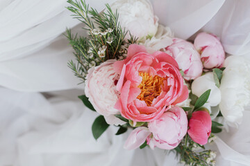 Beautiful stylish peonies bouquet on soft white fabric. Mothers day. Bridal morning. Space for text