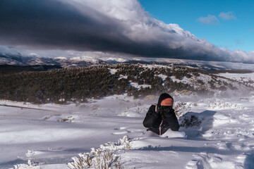 Chica haciendo fotos en la montaña nevada