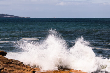 big waves crashing against rocky shoreline in Tasmania, Australia