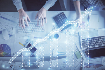 Double exposure of man and woman working together and financial chart hologram drawing. market analysis concept. Computer background. Top View.