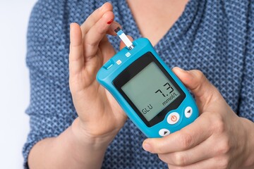 Woman is checking blood sugar level with glucose meter