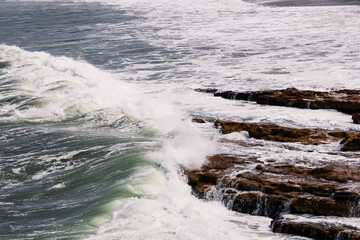 big waves crashing against rocky shoreline in Tasmania, Australia